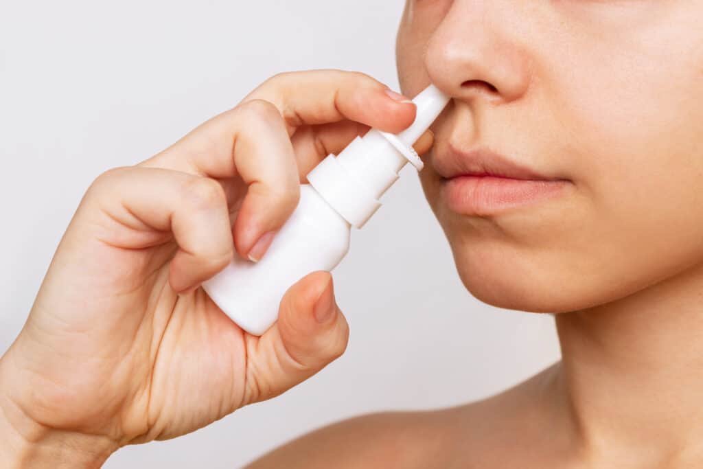 person using nasal spray